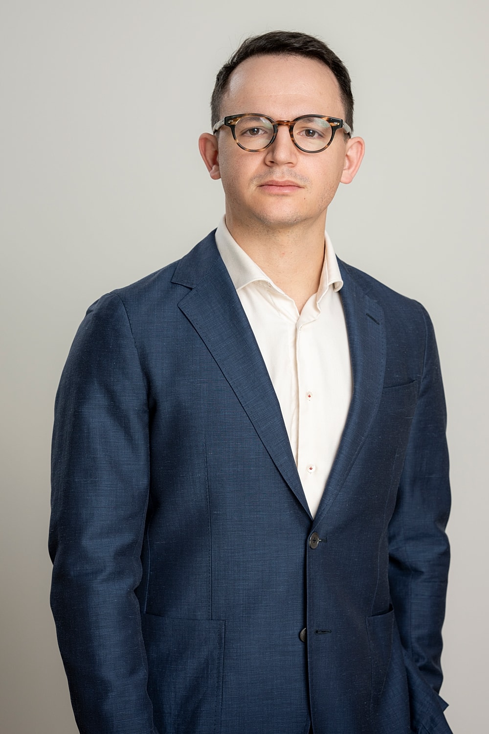 Confident man in a suit and glasses.
