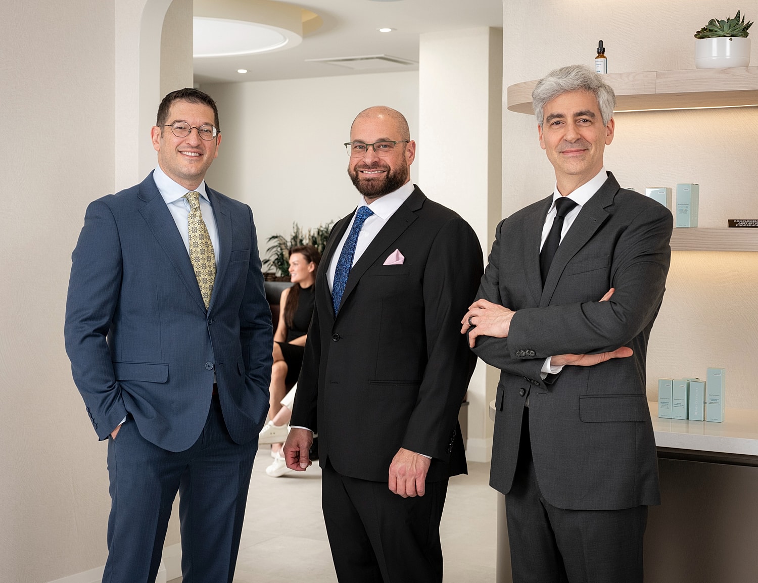 Three professionals in a modern office setting.