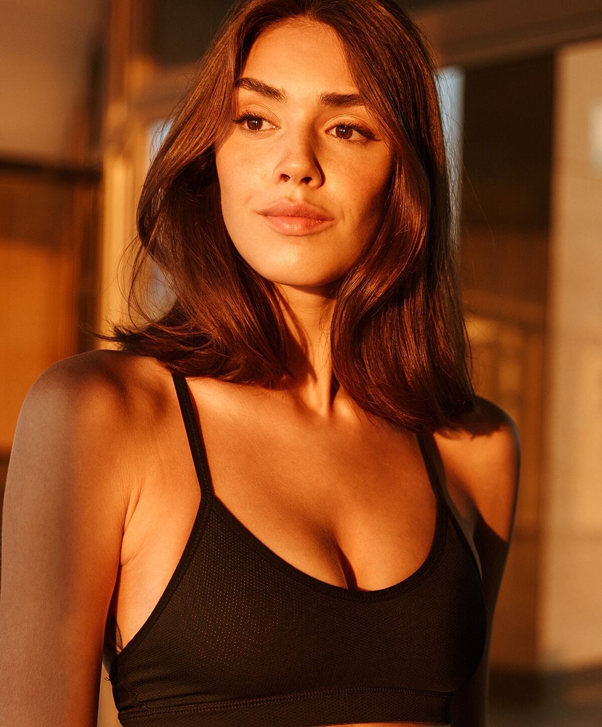 Woman in black athletic top during golden hour.