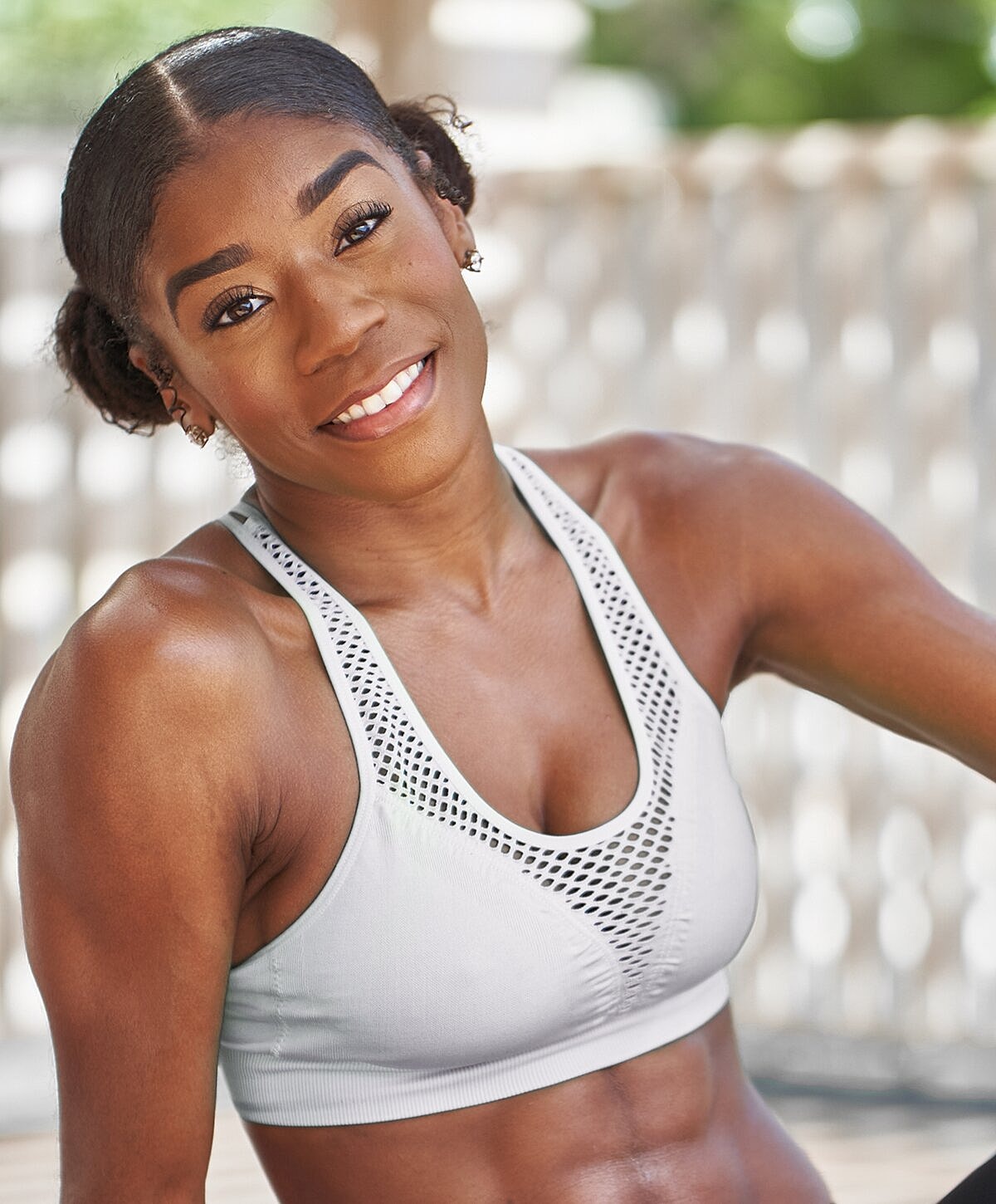 Smiling athlete in sports bra outdoors.