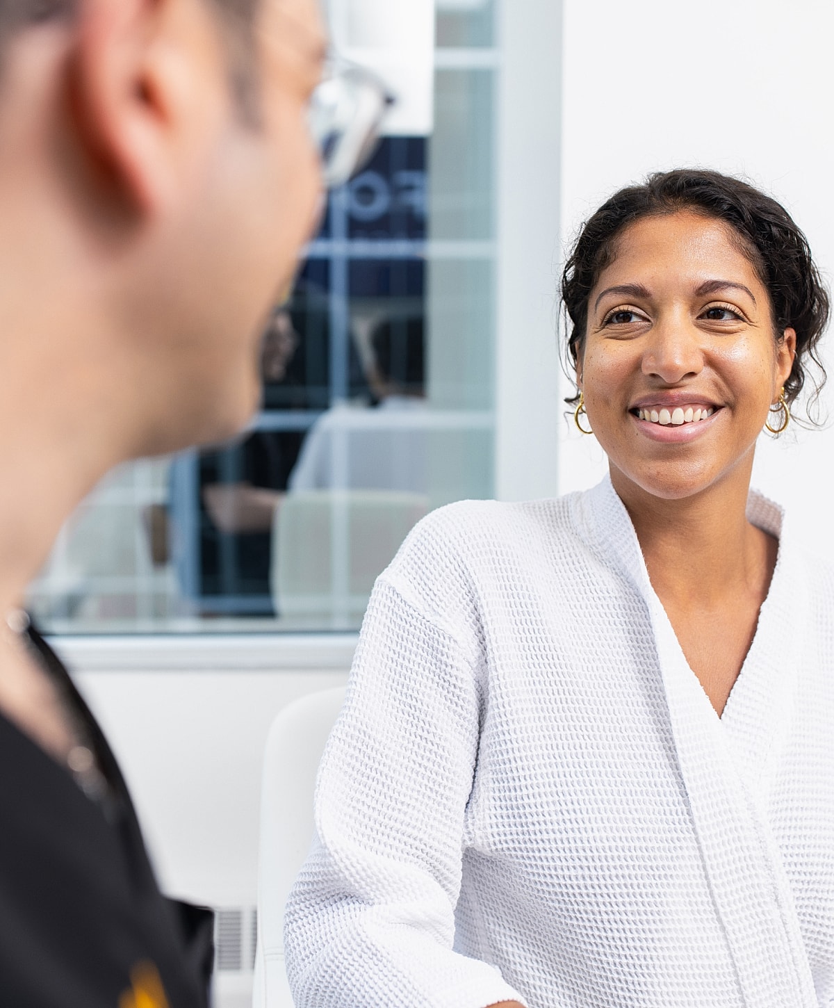 Smiling woman in spa setting, engaging conversation.