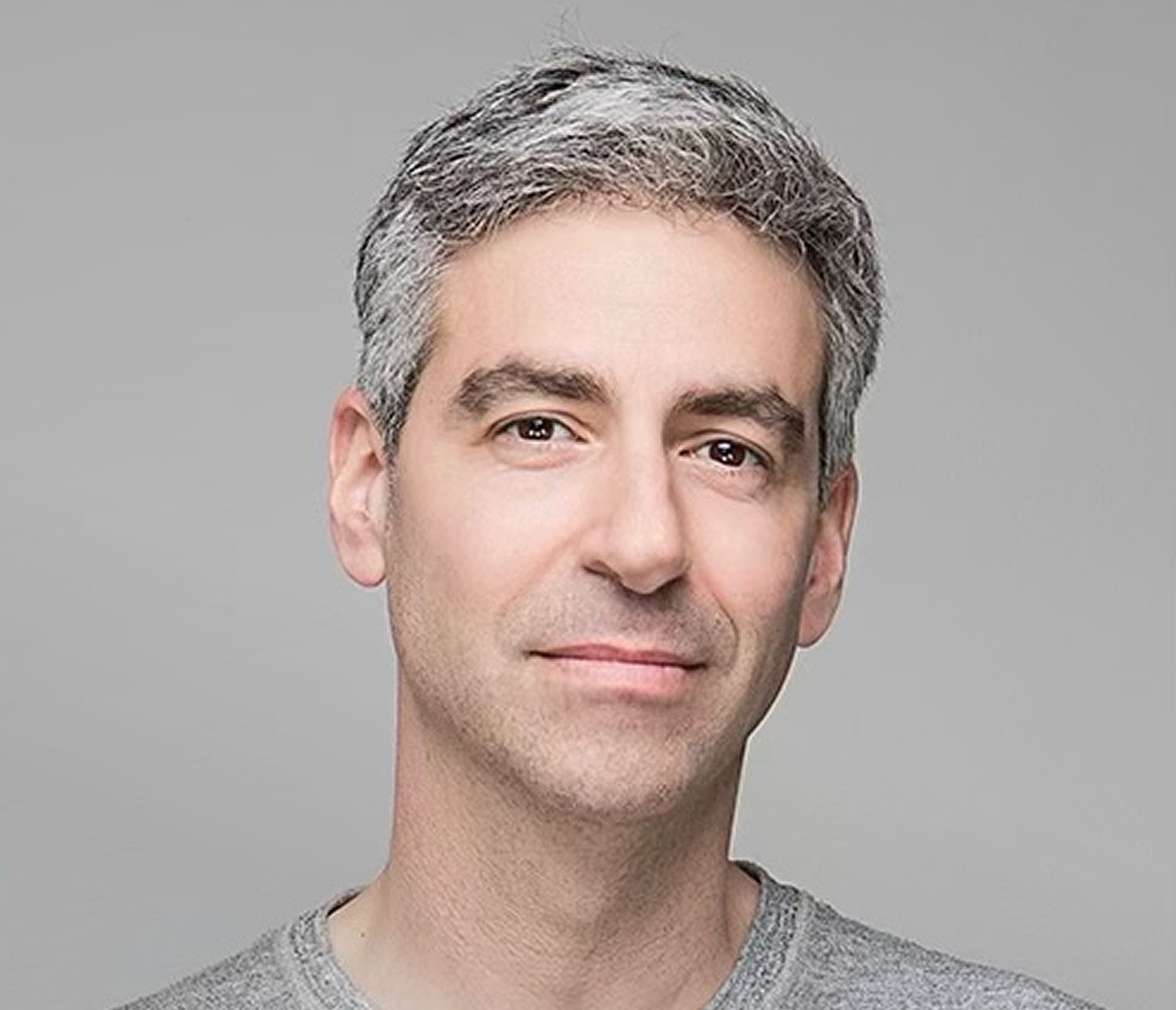 Man with short gray hair smiling warmly.
