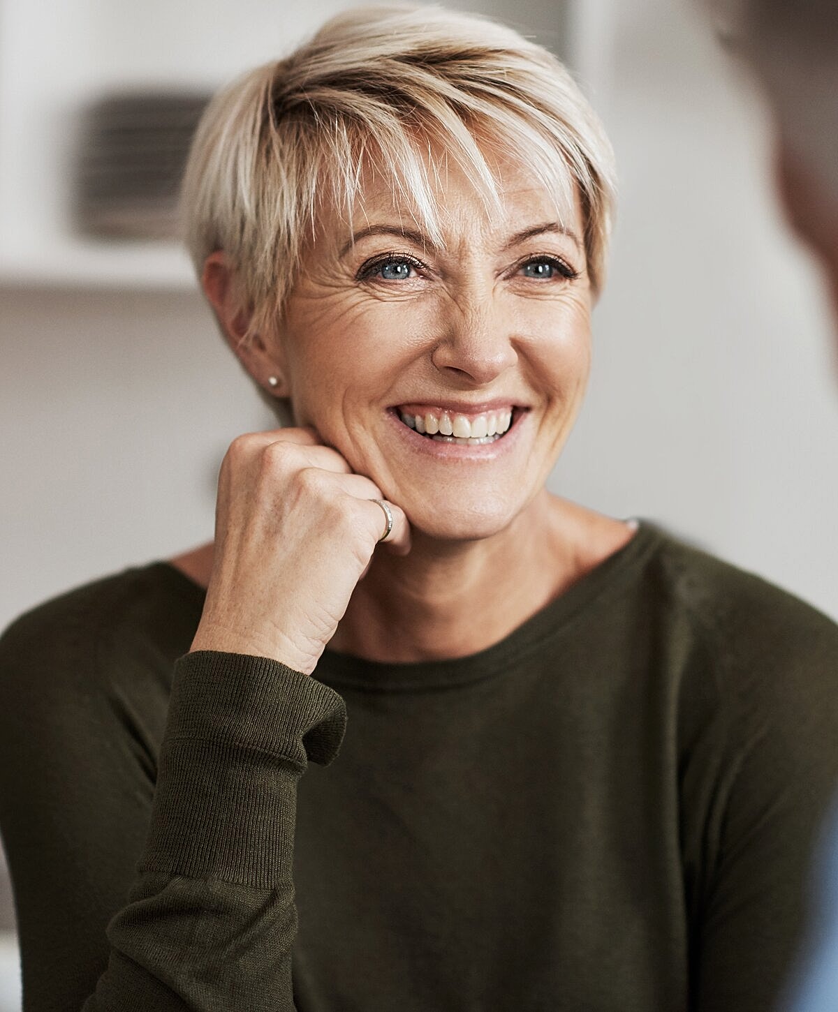 Smiling older woman with short, stylish hair.