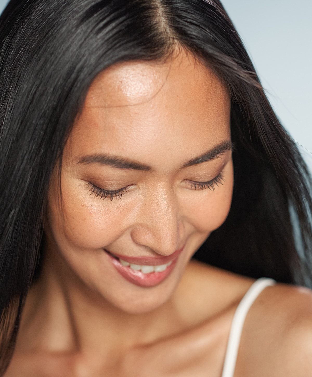 Smiling woman with long, dark hair.