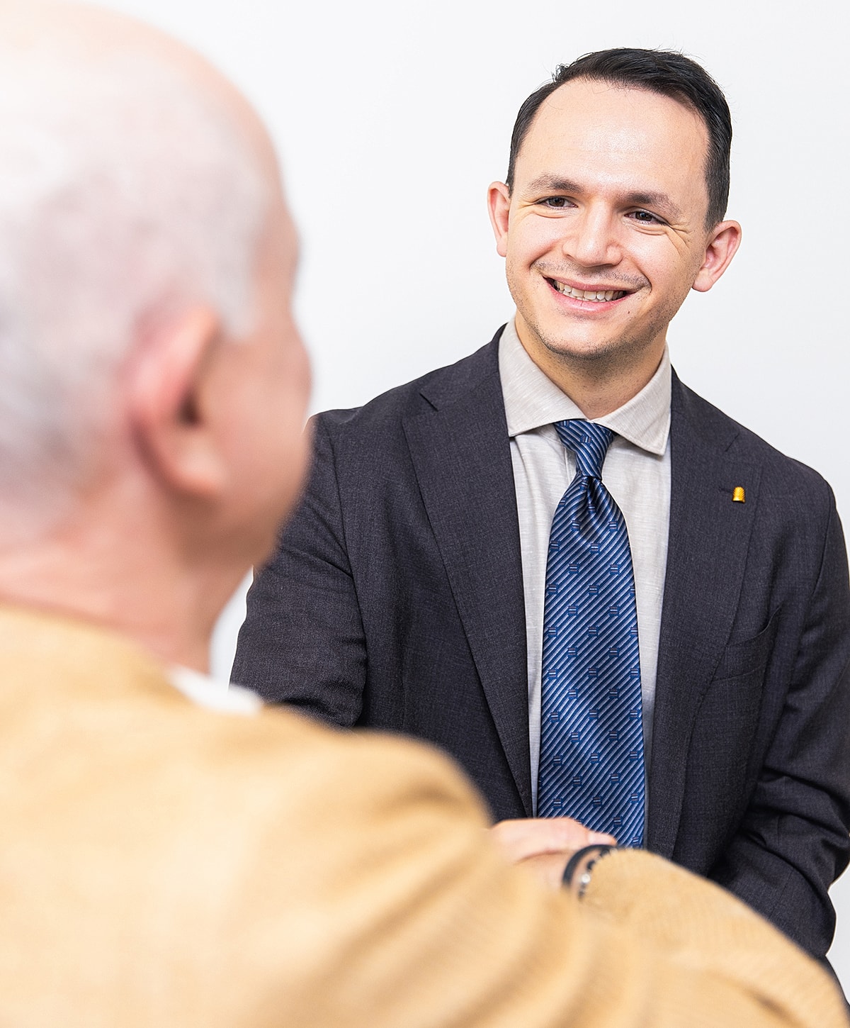 Two people shaking hands in a business setting.