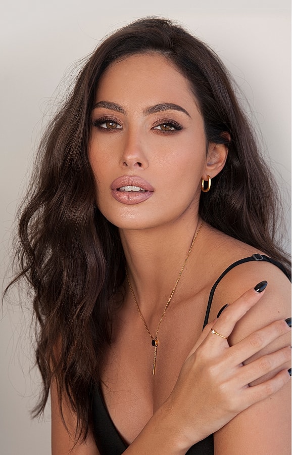 Woman with wavy hair and elegant jewelry.