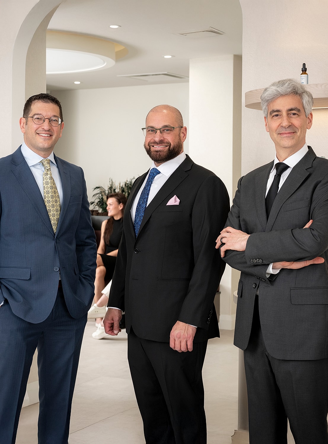Three professionals posing in a modern office.