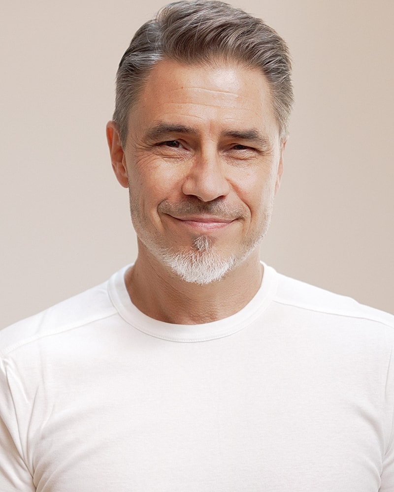 Smiling man with short gray hair and beard.