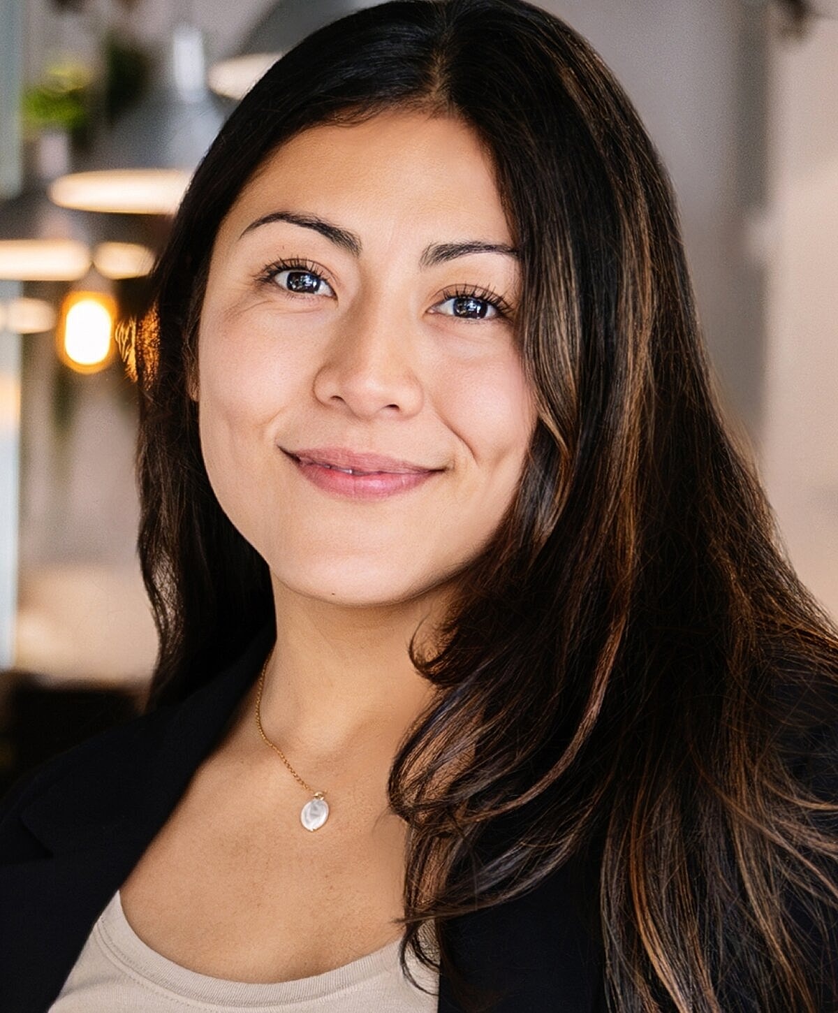 Smiling woman in professional attire, close-up portrait.