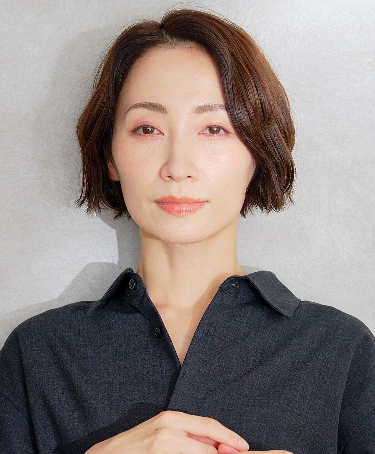 Woman with short hair in a black shirt.