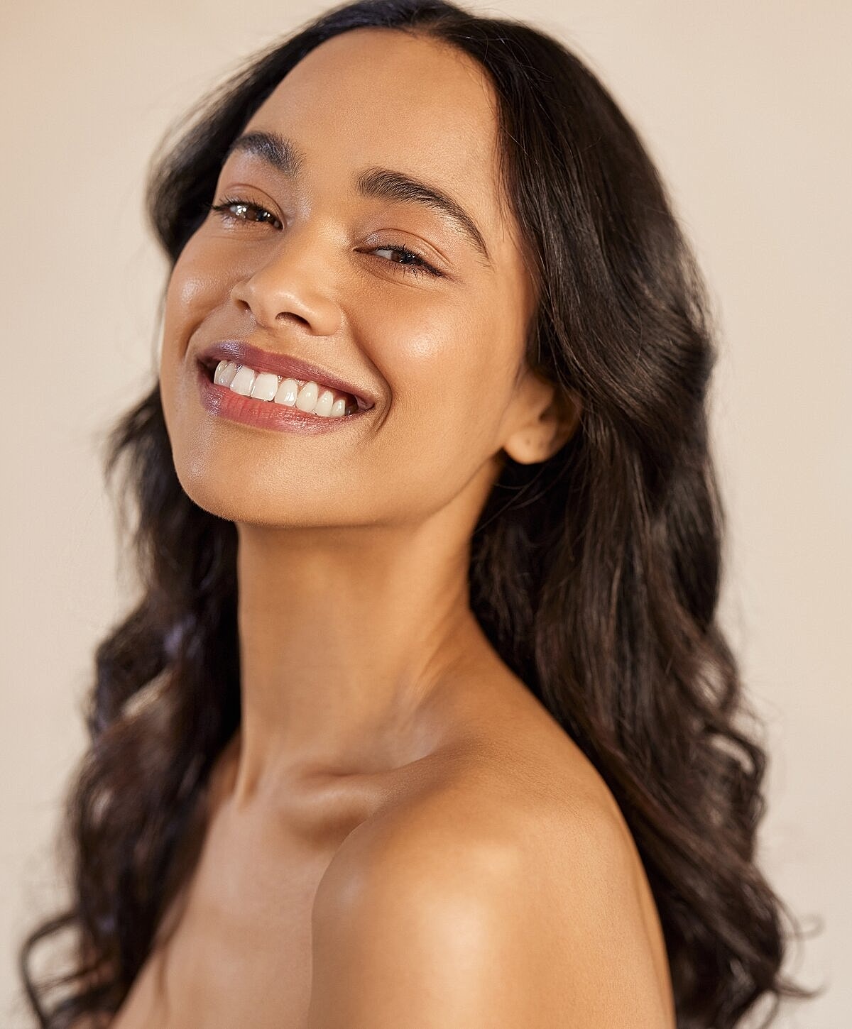 Smiling woman with long, wavy hair.