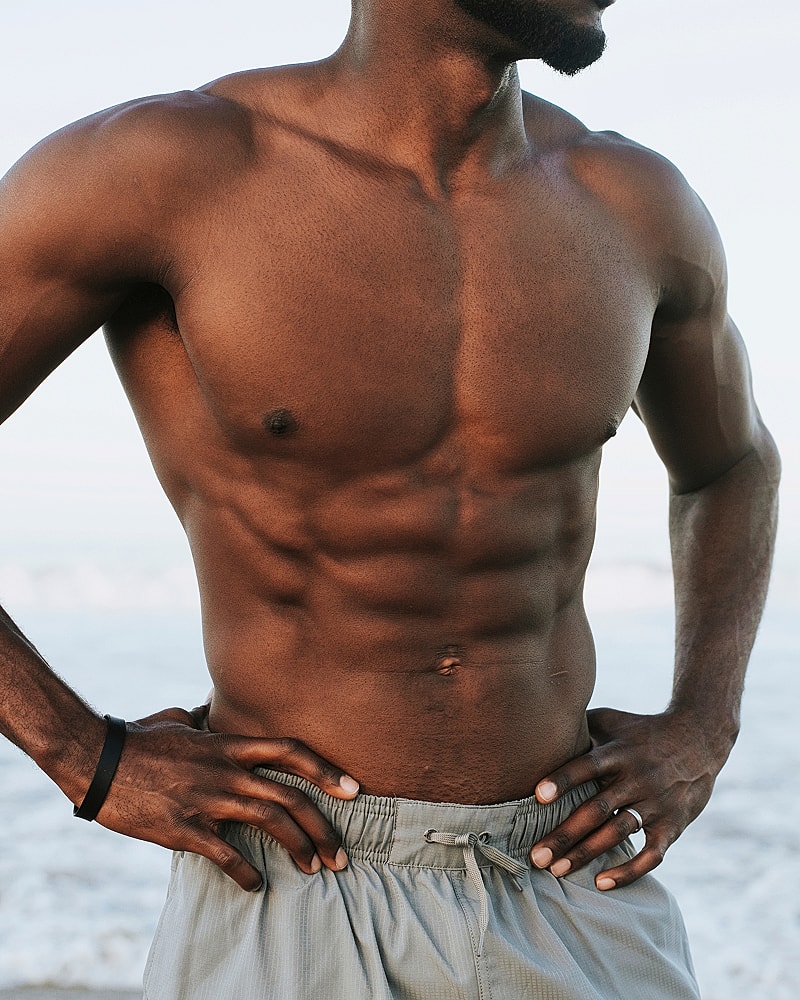 Man with toned abs at the beach.