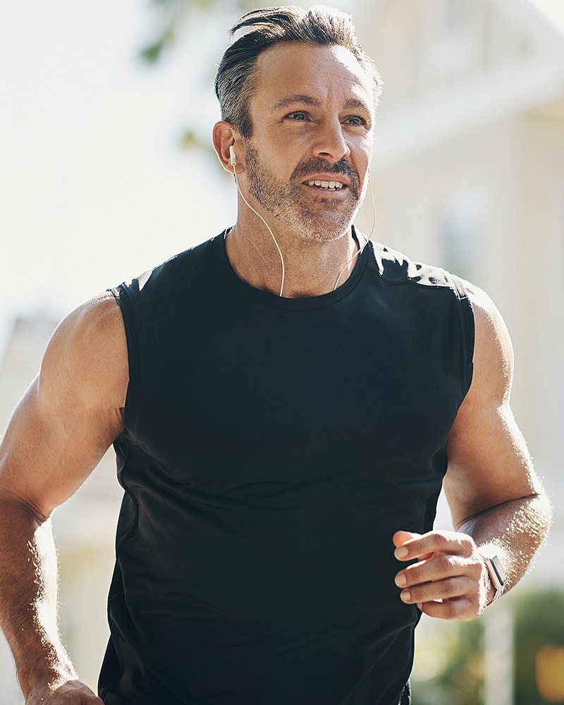 Man jogging outdoors with headphones on.