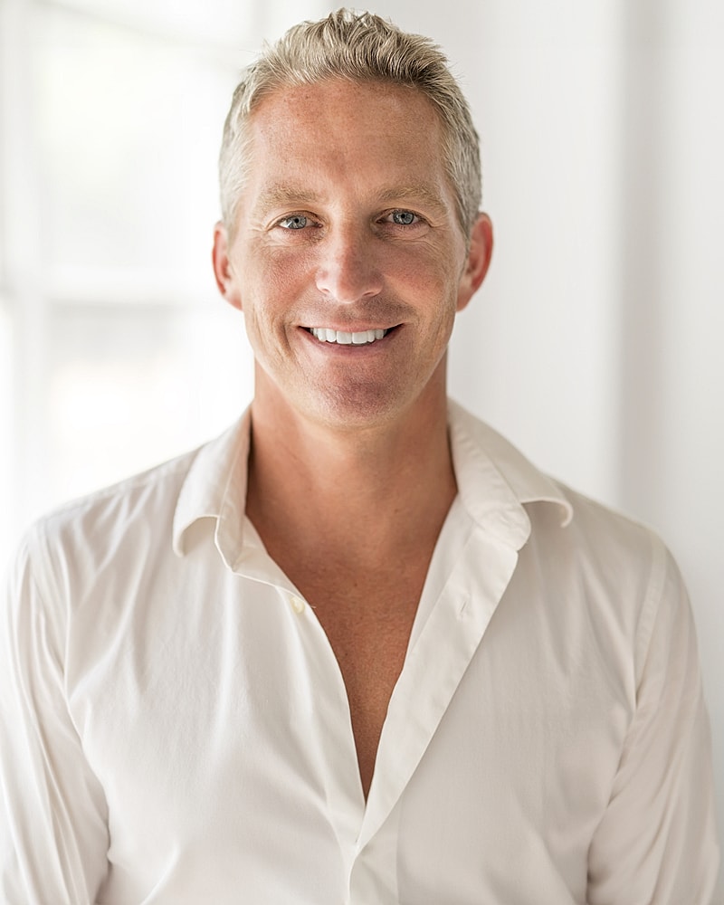 Smiling man in a white shirt indoors.