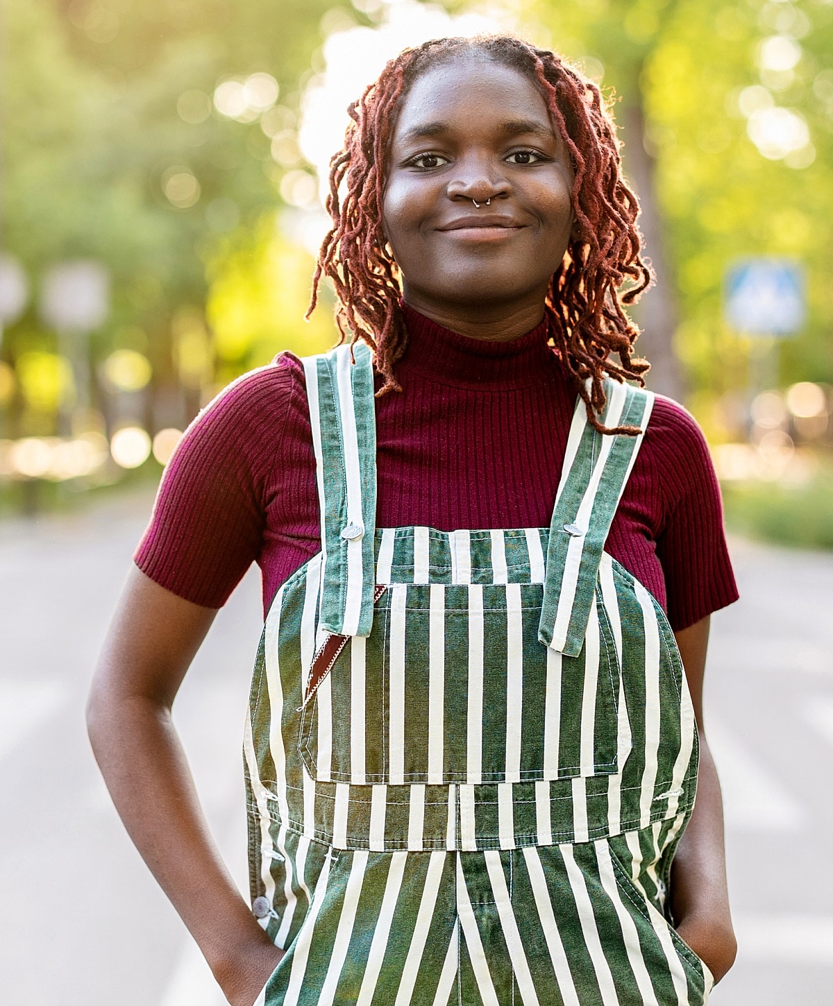 Person wearing striped overalls in nature setting.