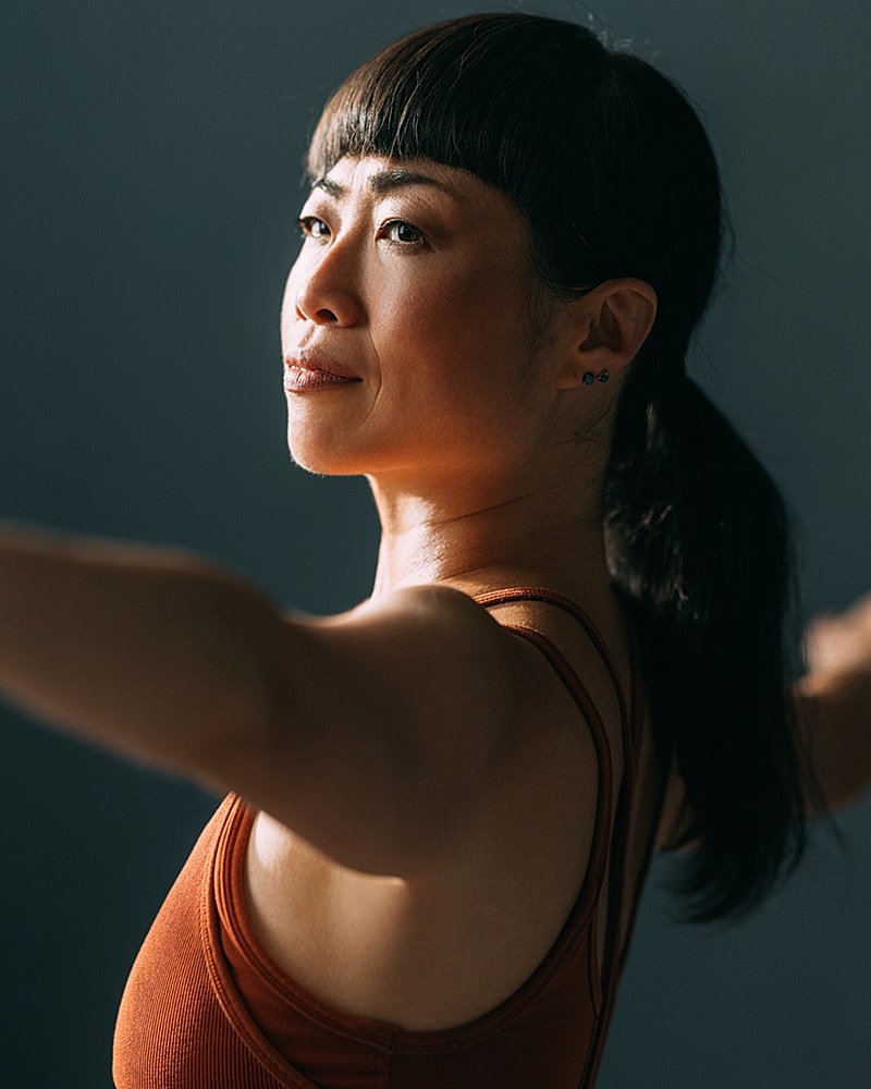 Woman stretching in athletic wear, side profile.