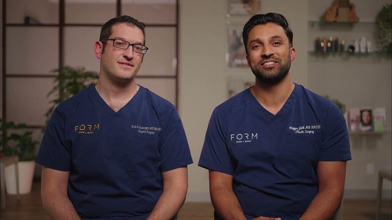 Two plastic surgeons in blue scrubs sitting together.